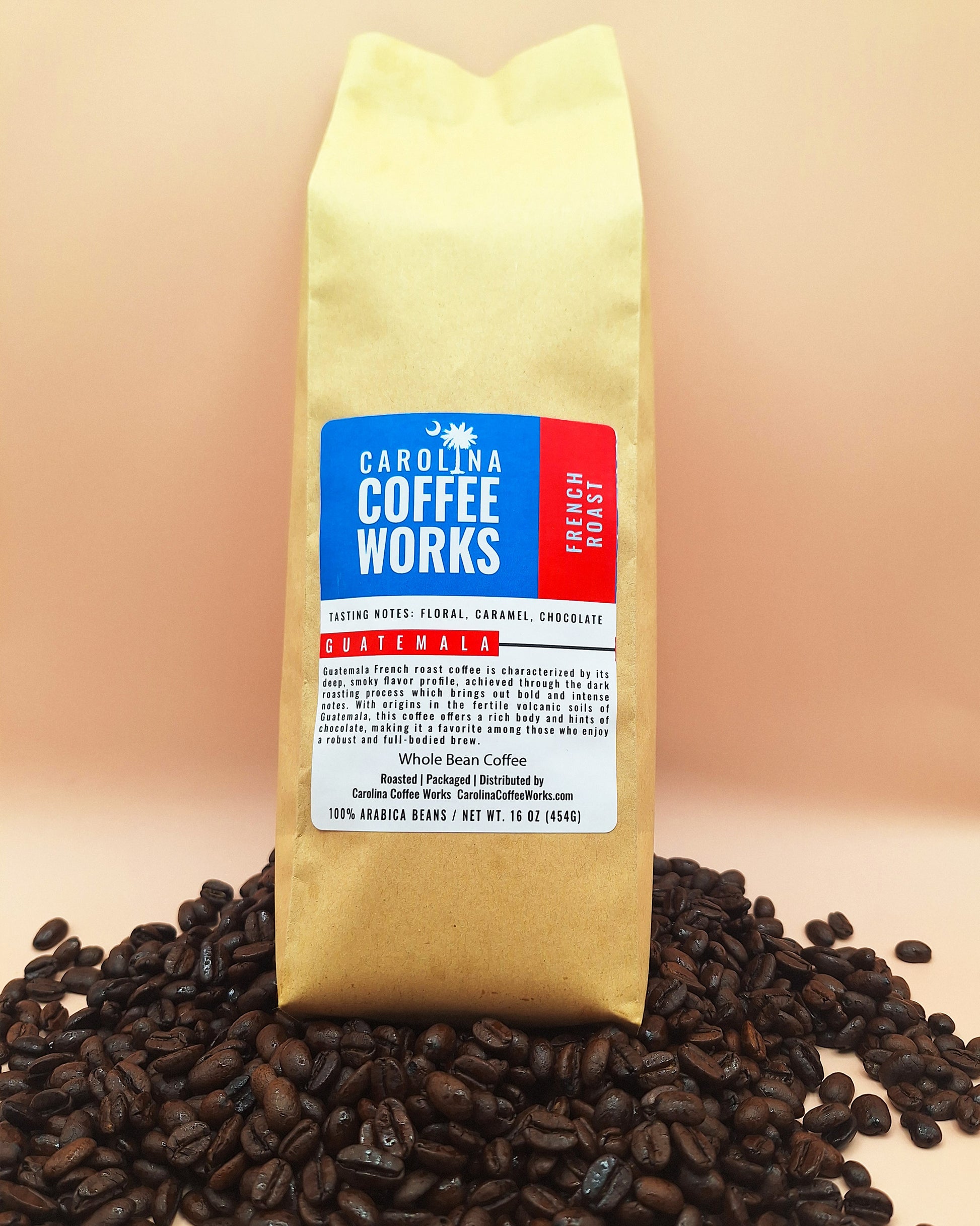 A bag of Carolina Coffee Works French Roast Coffee placed on top of a stack of coffee beans against a tan background. 